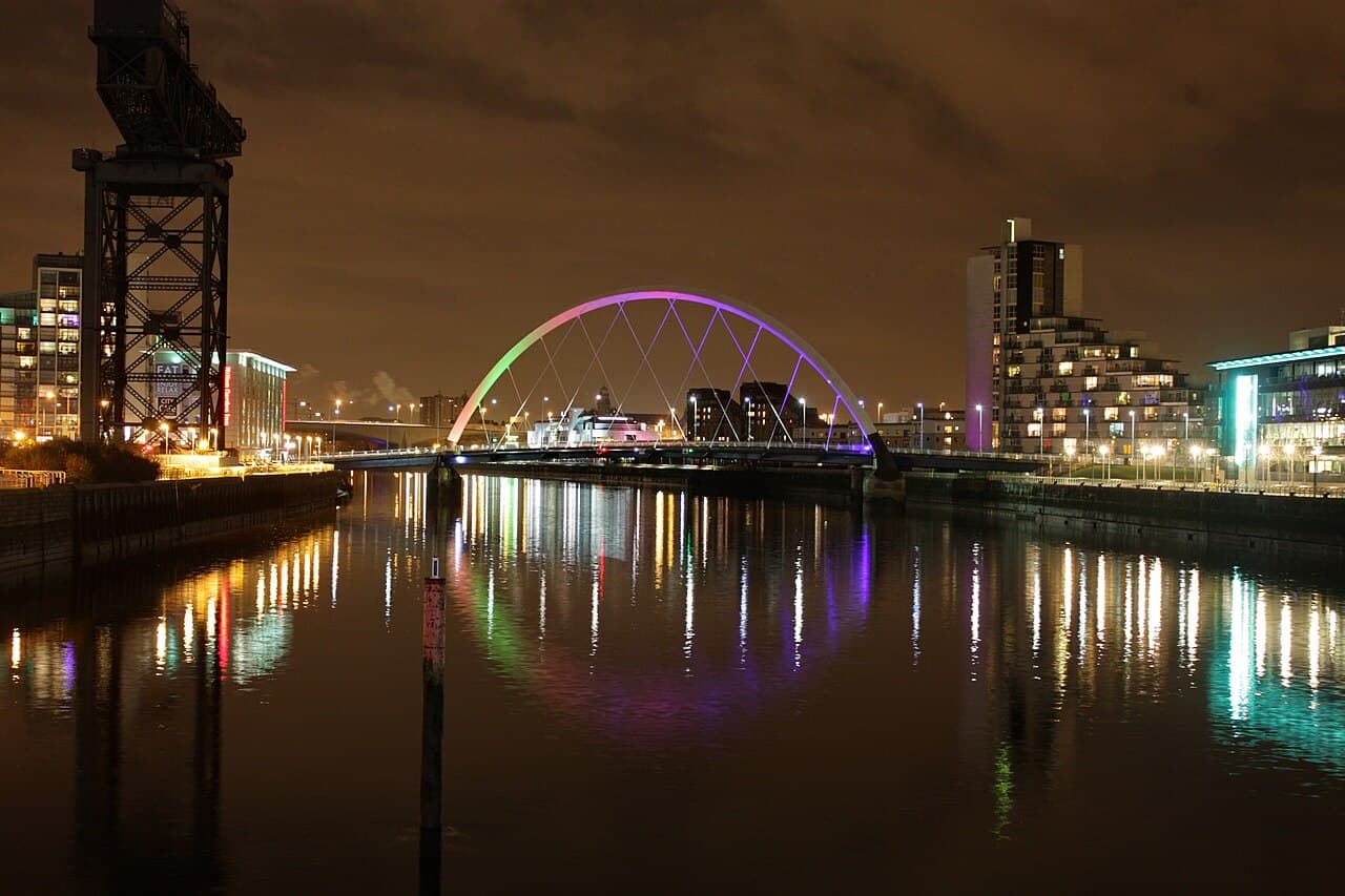 The Clyde Arc bridge lit up at night over the River Clyde in Glasgow, Scotland