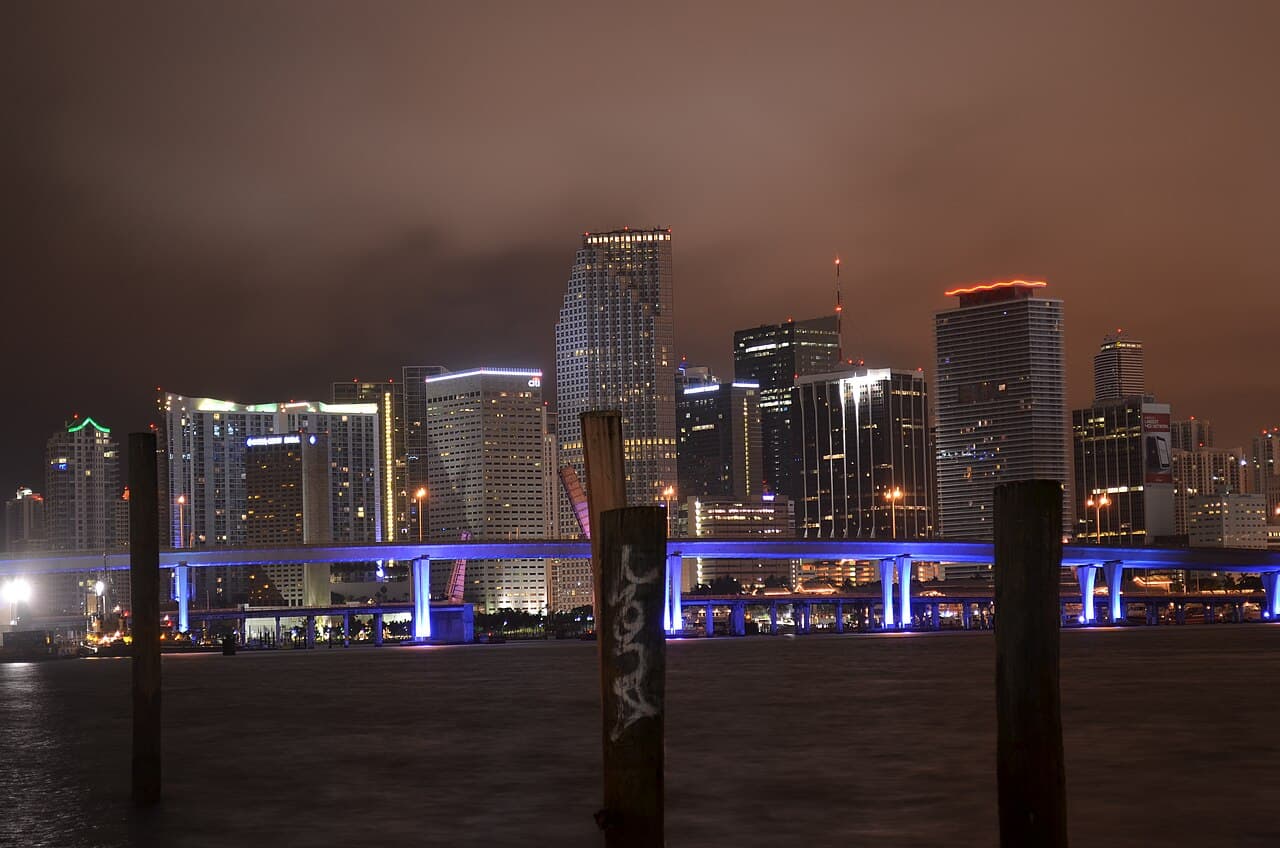 Downtown Miami's skyline at night from across Biscayne Bay — the city whose house and techno scene splits between Downtown's Club Space complex and South Beach